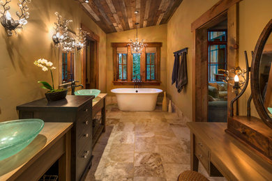 Example of a large mountain style master ceramic tile and brown floor freestanding bathtub design in Sacramento with furniture-like cabinets, brown walls, a vessel sink and wood countertops