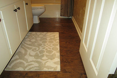 Bathroom - traditional vinyl floor bathroom idea in New Orleans with white cabinets, granite countertops and a one-piece toilet