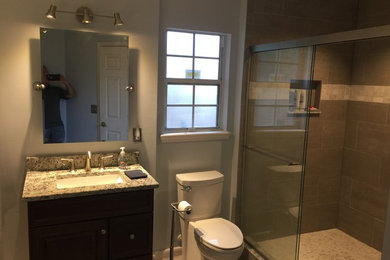 Ejemplo de cuarto de baño clásico renovado de tamaño medio con armarios con paneles empotrados, puertas de armario de madera en tonos medios, ducha abierta, sanitario de una pieza, paredes blancas, aseo y ducha, lavabo encastrado y encimera de granito
