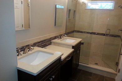 Small transitional master brown tile and ceramic tile ceramic tile doorless shower photo in Jacksonville with recessed-panel cabinets, dark wood cabinets, a one-piece toilet, white walls, a pedestal sink and granite countertops