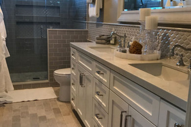 Inspiration for a mid-sized timeless 3/4 beige tile and glass tile brick floor and beige floor bathroom remodel in San Diego with recessed-panel cabinets, white cabinets, beige walls, a drop-in sink and quartz countertops