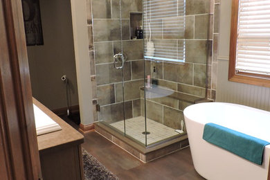 Inspiration for a medium sized traditional ensuite bathroom in Columbus with raised-panel cabinets, medium wood cabinets, a freestanding bath, a corner shower, beige tiles, porcelain tiles, beige walls, a built-in sink, granite worktops and porcelain flooring.