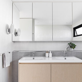 This is an example of a mid-sized contemporary master bathroom in Sydney with light wood cabinets, white tile, gray tile, ceramic tile, white walls, porcelain floors, grey floor, a double vanity, a floating vanity, flat-panel cabinets, an integrated sink and white benchtops.