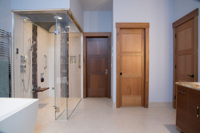 Huge transitional master beige tile and ceramic tile porcelain tile and beige floor bathroom photo in Seattle with flat-panel cabinets, medium tone wood cabinets, a bidet, purple walls, a vessel sink, quartzite countertops and a hinged shower door