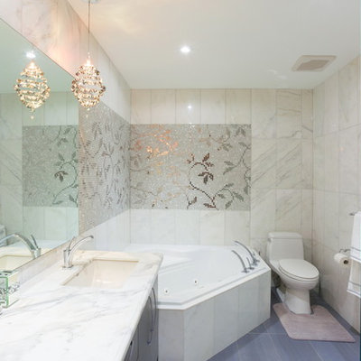 Bathroom - large transitional master white tile and stone tile porcelain tile and gray floor bathroom idea in Toronto with an undermount sink, a one-piece toilet, gray cabinets, white walls, marble countertops, flat-panel cabinets and a hinged shower door
