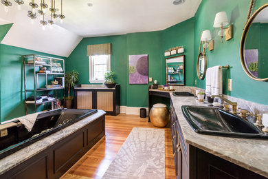 Eklektisk inredning av ett stort en-suite badrum, med luckor med infälld panel, svarta skåp, ett platsbyggt badkar, gröna väggar, mellanmörkt trägolv, ett nedsänkt handfat, marmorbänkskiva och brunt golv