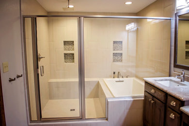Large mountain style master beige tile and ceramic tile ceramic tile and beige floor bathroom photo in Denver with raised-panel cabinets, dark wood cabinets, a two-piece toilet, beige walls, an undermount sink, granite countertops, a hinged shower door and multicolored countertops