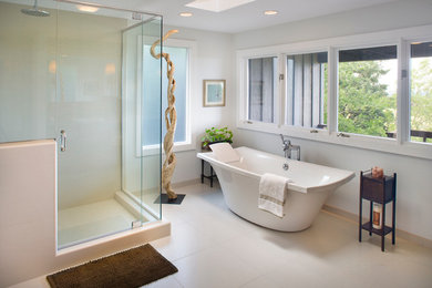 Imagen de cuarto de baño actual con bañera exenta y ventanas