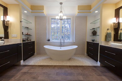 Design ideas for a large contemporary ensuite bathroom in New York with flat-panel cabinets, brown cabinets, a freestanding bath, a corner shower, a two-piece toilet, white tiles, porcelain tiles, yellow walls, pebble tile flooring, a vessel sink, quartz worktops, beige floors and a hinged door.