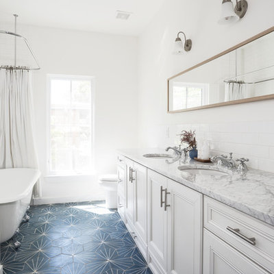 Example of a mid-sized farmhouse kids' white tile and subway tile blue floor claw-foot bathtub design in Austin with white cabinets, a two-piece toilet, white walls, an undermount sink, marble countertops, a hinged shower door, beaded inset cabinets and gray countertops