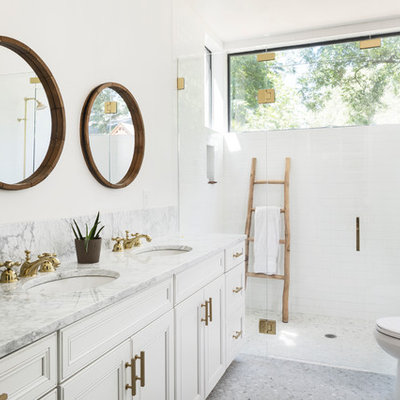 Example of a mid-sized country master white tile and subway tile mosaic tile floor and gray floor walk-in shower design in Austin with white cabinets, a two-piece toilet, white walls, an undermount sink, marble countertops, a hinged shower door, beaded inset cabinets and gray countertops
