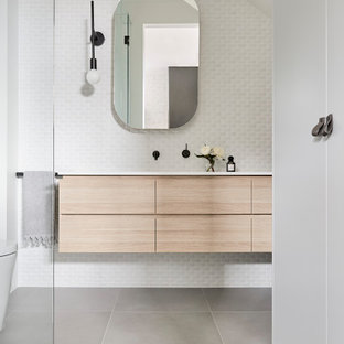 This is an example of a contemporary bathroom in Melbourne with flat-panel cabinets, light wood cabinets, white tile, mosaic tile, white walls, an undermount sink, grey floor, white benchtops, a single vanity, a floating vanity and vaulted.