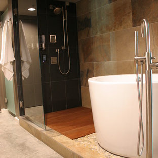 Inspiration pour une petit salle de bain principale traditionnelle avec un placard à porte plane, des portes de placard en bois brun, un bain japonais, une douche ouverte, un bidet, un carrelage noir, un carrelage de pierre, un mur gris, béton au sol, un lavabo intégré, un plan de toilette en quartz, un sol gris, une cabine de douche à porte battante et un plan de toilette gris.