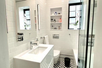 Example of a mid-sized trendy master white tile and subway tile marble floor and single-sink bathroom design in Toronto with flat-panel cabinets, white cabinets, a wall-mount toilet, white walls, an integrated sink, quartz countertops, a hinged shower door, white countertops, a niche and a floating vanity