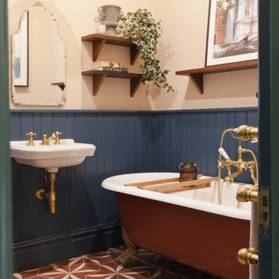 Inspiration for a transitional cement tile floor and red floor claw-foot bathtub remodel in London with multicolored walls and a wall-mount sink