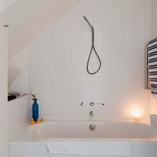 Idées déco pour une petit salle de bain contemporaine pour enfant avec une baignoire posée, une douche à l'italienne, un WC suspendu, un carrelage blanc, un mur blanc, un sol en terrazzo, un lavabo suspendu, un sol blanc et une cabine de douche à porte battante.