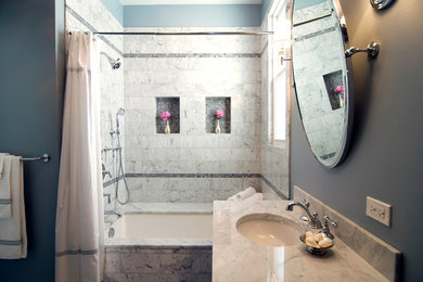 Mid-sized white tile and stone tile marble floor tub/shower combo photo in Chicago with an undermount sink, furniture-like cabinets, gray cabinets, marble countertops, an undermount tub and gray walls