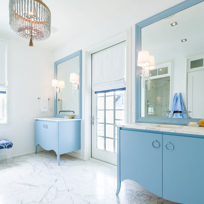 Example of a beach style white floor bathroom design in Miami with flat-panel cabinets, blue cabinets, white walls, an undermount sink and white countertops