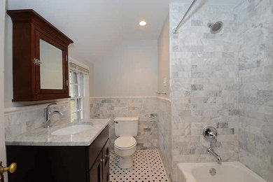 Example of a mid-sized classic 3/4 stone tile mosaic tile floor bathroom design in Philadelphia with shaker cabinets, dark wood cabinets, a two-piece toilet, white walls, an undermount sink and marble countertops