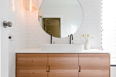 Réalisation d'une salle de bain design avec une grande vasque, un mur blanc, un carrelage blanc, un carrelage métro et du carrelage bicolore.
