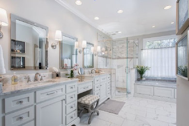Example of a large classic master beige tile, gray tile, white tile and stone tile marble floor corner shower design in Atlanta with recessed-panel cabinets, white cabinets, an undermount tub, gray walls, an undermount sink and solid surface countertops