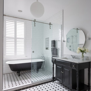 Ispirazione per una stanza da bagno padronale vittoriana con ante nere, vasca con piedi a zampa di leone, vasca/doccia, piastrelle di vetro, pareti bianche, pavimento con piastrelle in ceramica, lavabo sottopiano e ante con bugna sagomata