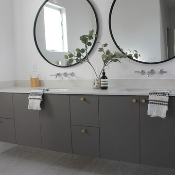 Round Bath Mirrors Over Vanity with Brass Sconces