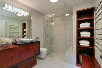 Example of a mid-sized 3/4 ceramic tile and white floor bathroom design in Vancouver with open cabinets, dark wood cabinets, a wall-mount toilet, white walls and a vessel sink