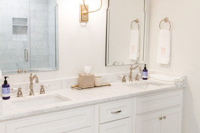 Mid-sized minimalist master white tile and marble tile marble floor, white floor and double-sink alcove shower photo in Miami with shaker cabinets, white cabinets, a two-piece toilet, white walls, an undermount sink, marble countertops, a hinged shower door, white countertops and a built-in vanity