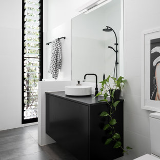 Contemporary 3/4 bathroom in Perth with flat-panel cabinets, black cabinets, white tile, white walls, a vessel sink, grey floor, black benchtops, a single vanity and a floating vanity.