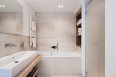 アムステルダムにある高級な小さなラスティックスタイルのおしゃれなマスターバスルーム (落し込みパネル扉のキャビネット、淡色木目調キャビネット、大型浴槽、ベージュのタイル、セラミックタイル、木製洗面台) の写真