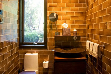 Ispirazione per una stanza da bagno contemporanea di medie dimensioni con lavabo a consolle, ante in legno bruno, top in legno, doccia doppia, WC monopezzo, ante lisce e pavimento con piastrelle di ciottoli