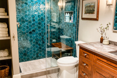 Example of a mountain style green tile and terra-cotta tile ceramic tile and gray floor sliding shower door design in Other with shaker cabinets, brown cabinets, a two-piece toilet, gray walls, an undermount sink, quartz countertops and gray countertops