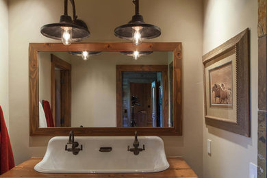 Modelo de cuarto de baño rural extra grande con lavabo encastrado, armarios abiertos, puertas de armario con efecto envejecido, encimera de madera, paredes beige y aseo y ducha