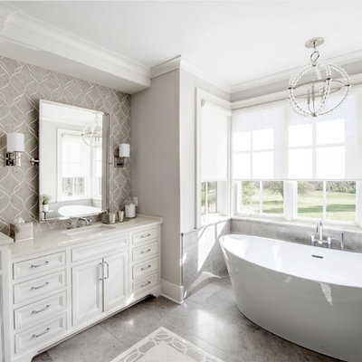 Freestanding bathtub - large traditional master porcelain tile and gray floor freestanding bathtub idea in Columbus with beaded inset cabinets, white cabinets, gray walls, an undermount sink, marble countertops and white countertops