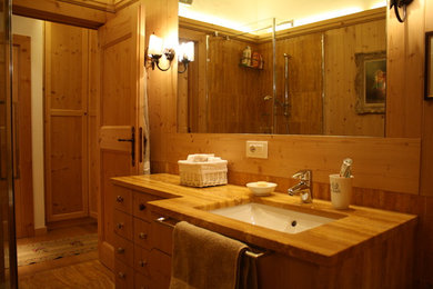 Ejemplo de cuarto de baño principal rústico de tamaño medio con armarios tipo mueble, puertas de armario de madera clara y suelo de mármol