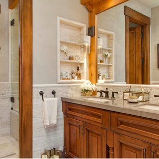 This is an example of a country bathroom in Seattle with an undermount sink, raised-panel cabinets, medium wood cabinets, an alcove shower, a one-piece toilet, beige walls, ceramic floors and beige floor.