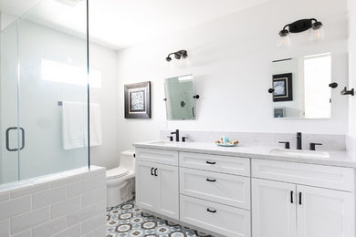 Medium sized classic ensuite bathroom in Sacramento with shaker cabinets, white cabinets, a one-piece toilet, grey tiles, metro tiles, grey walls, ceramic flooring, a submerged sink, engineered stone worktops, blue floors, a hinged door and grey worktops.
