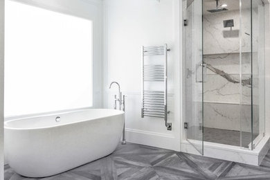 Large trendy master gray tile and marble tile medium tone wood floor and gray floor bathroom photo in New York with flat-panel cabinets, dark wood cabinets, white walls, solid surface countertops, a hinged shower door and white countertops