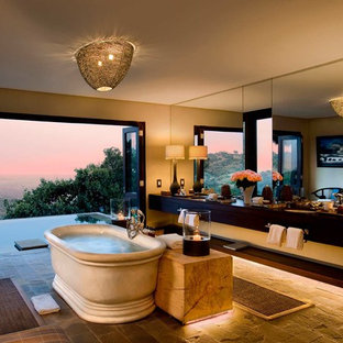 Large world-inspired ensuite bathroom in Other with a freestanding bath, yellow tiles, yellow walls, a built-in sink, flat-panel cabinets, black cabinets and grey floors.