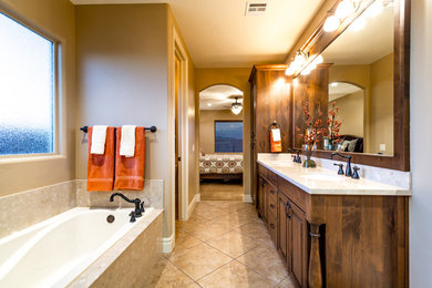 Inredning av ett klassiskt stort en-suite badrum, med luckor med upphöjd panel, skåp i mörkt trä, ett platsbyggt badkar, beige väggar, klinkergolv i keramik, ett undermonterad handfat och bänkskiva i kvarts