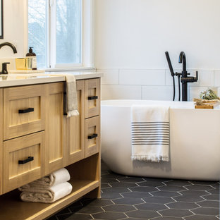 Inspiration for a mid-sized farmhouse master white tile and subway tile porcelain tile and black floor bathroom remodel in Seattle with shaker cabinets, light wood cabinets, a one-piece toilet, white walls, an undermount sink, a hinged shower door, white countertops and quartz countertops