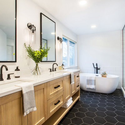 Example of a mid-sized farmhouse master white tile and subway tile porcelain tile, black floor and double-sink bathroom design in Seattle with shaker cabinets, white walls, an undermount sink, a hinged shower door, white countertops, quartz countertops, medium tone wood cabinets, a niche and a built-in vanity
