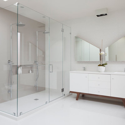 Example of a large trendy master white tile and porcelain tile ceramic tile and beige floor alcove shower design in San Francisco with white cabinets, white walls, flat-panel cabinets, a wall-mount toilet, an integrated sink, quartz countertops, a hinged shower door and white countertops