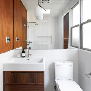 This is an example of a midcentury bathroom in San Francisco with flat-panel cabinets, dark wood cabinets, a two-piece toilet, white tile, white walls, a console sink, grey floor, a single vanity, a floating vanity, timber and wood walls.