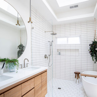 Inspiration for a country white tile white floor, double-sink and tray ceiling bathroom remodel in Seattle with flat-panel cabinets, medium tone wood cabinets, white walls, an undermount sink, white countertops and a niche