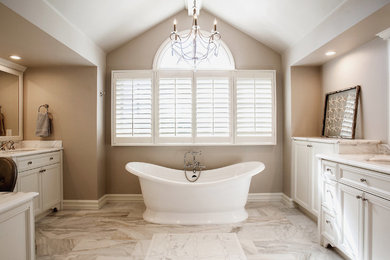 Freestanding bathtub - mid-sized transitional master black and white tile and stone slab marble floor freestanding bathtub idea in Orange County with recessed-panel cabinets, white cabinets, a one-piece toilet, beige walls, an undermount sink and marble countertops