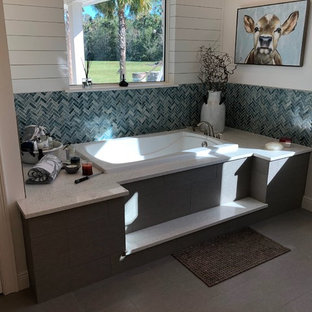 Immagine di una stanza da bagno padronale country di medie dimensioni con vasca da incasso, piastrelle multicolore, piastrelle di vetro, pareti grigie, pavimento con piastrelle in ceramica, top in granito e pavimento grigio