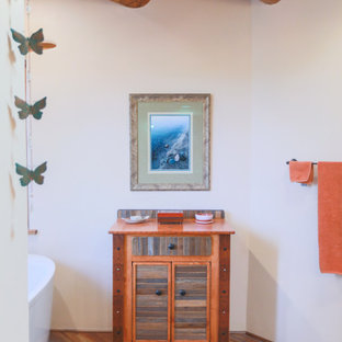 Immagine di un'ampia stanza da bagno padronale american style con ante in legno scuro, vasca ad alcova, doccia alcova, WC monopezzo, piastrelle multicolore, piastrelle in ceramica, pareti bianche, pavimento con piastrelle effetto legno, lavabo a colonna, top in superficie solida, pavimento multicolore, porta doccia a battente, top nero, toilette, due lavabi, mobile bagno incassato, travi a vista e ante con bugna sagomata