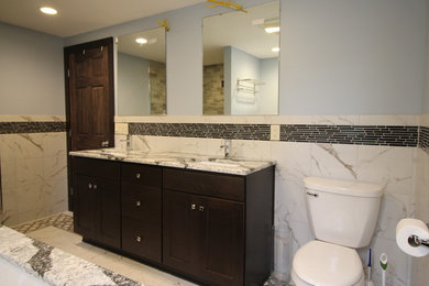 Large transitional master white tile and marble tile white floor and marble floor alcove shower photo in Other with recessed-panel cabinets, dark wood cabinets, an undermount tub, a two-piece toilet, gray walls, an undermount sink, a hinged shower door and granite countertops